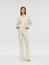 a lady wears a off white flared jeans with tweed jacket